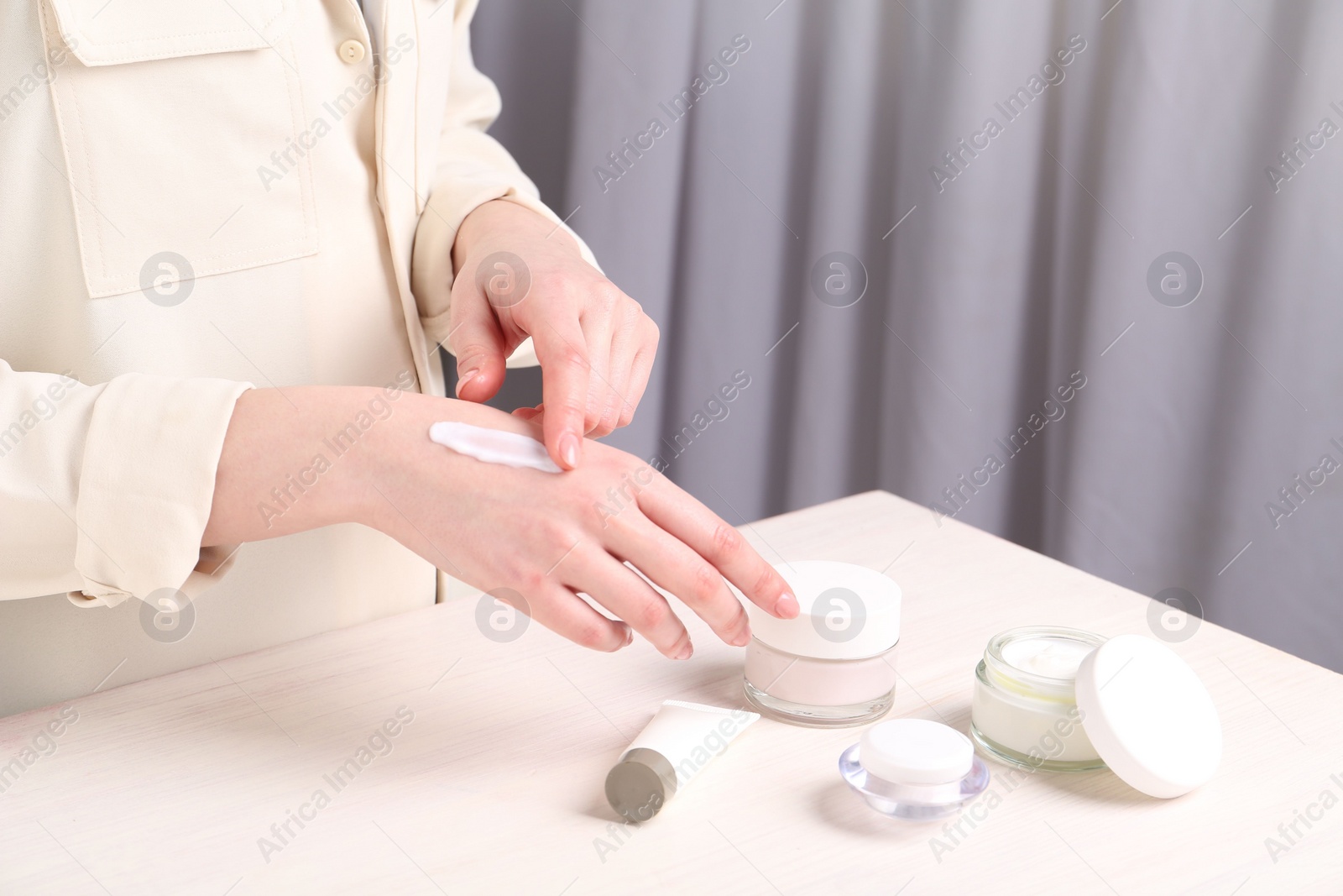 Photo of Woman applying hand cream at home, closeup