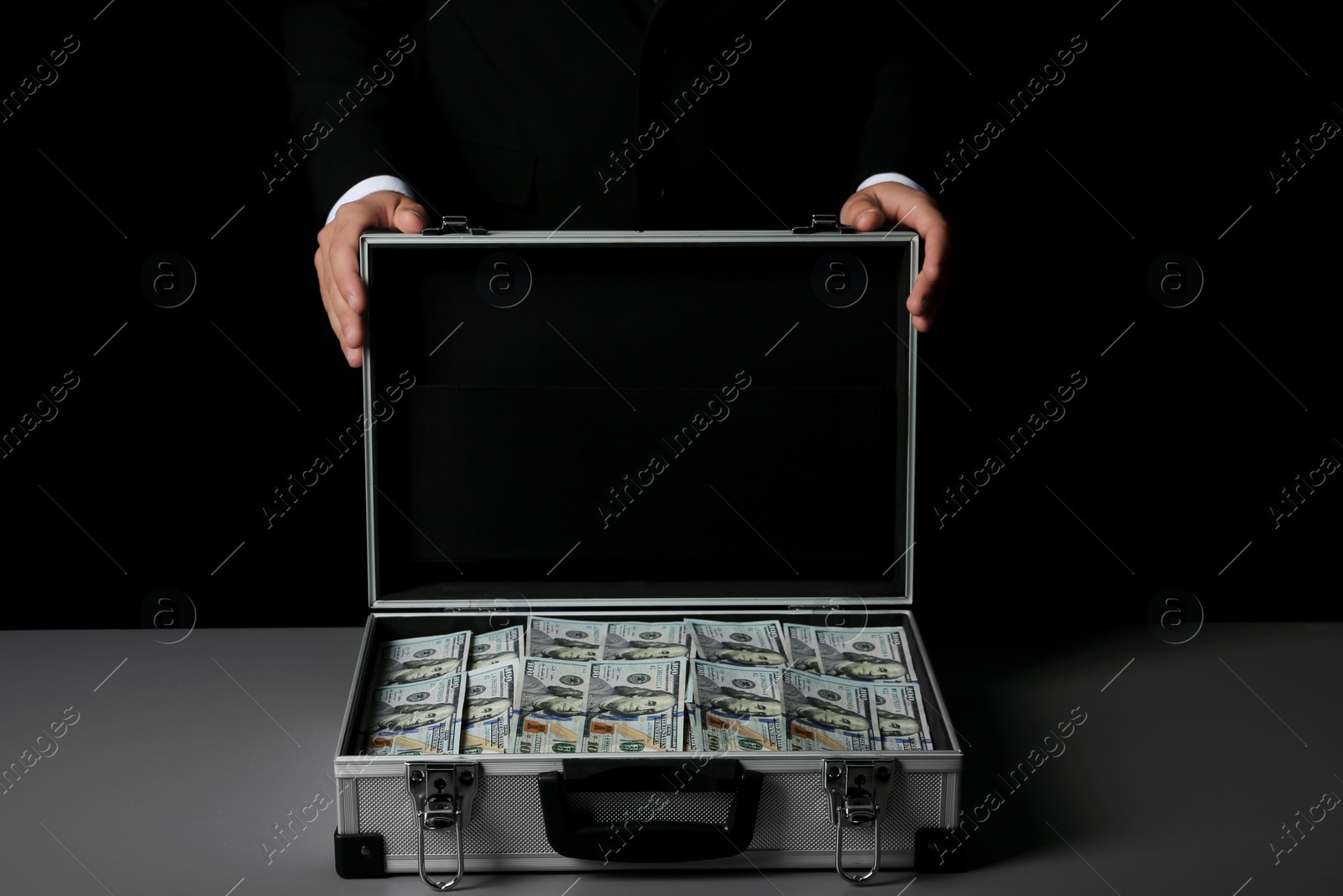 Photo of Businessman with suitcase full of money on dark background