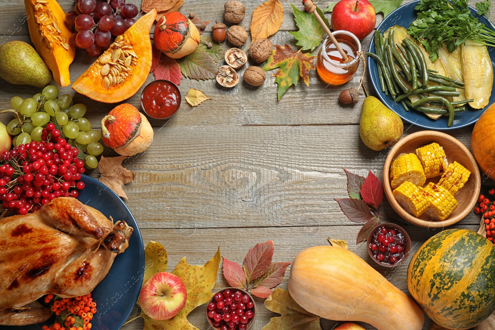 Photo of Frame made of delicious turkey, autumn vegetables and fruits on wooden background, flat lay with space for text. Happy Thanksgiving day