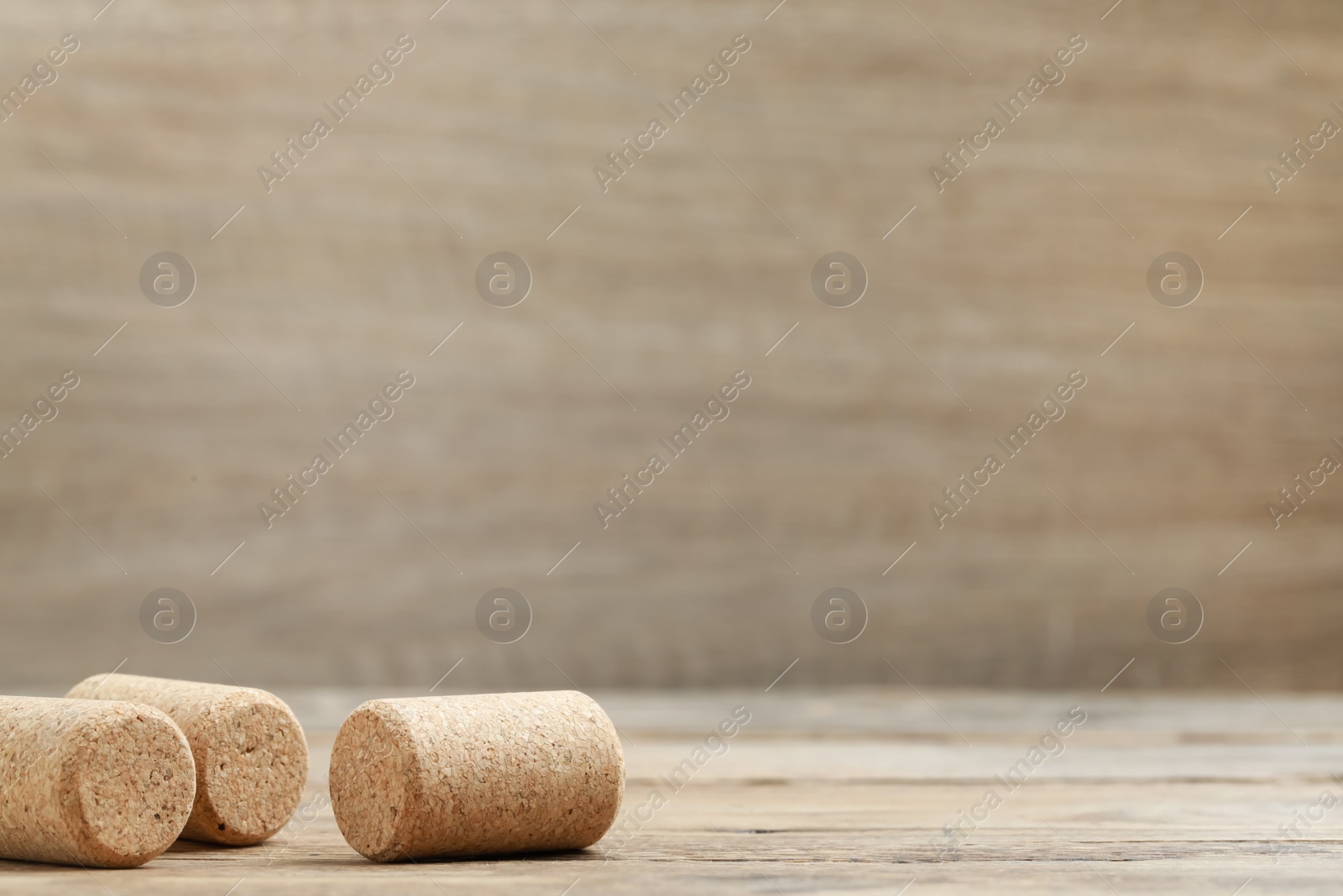 Photo of Corks of wine bottles on wooden table. Space for text
