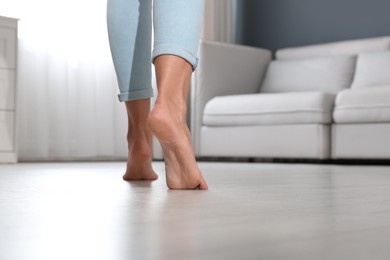 Photo of Woman walking barefoot at home, space for text. Floor heating concept
