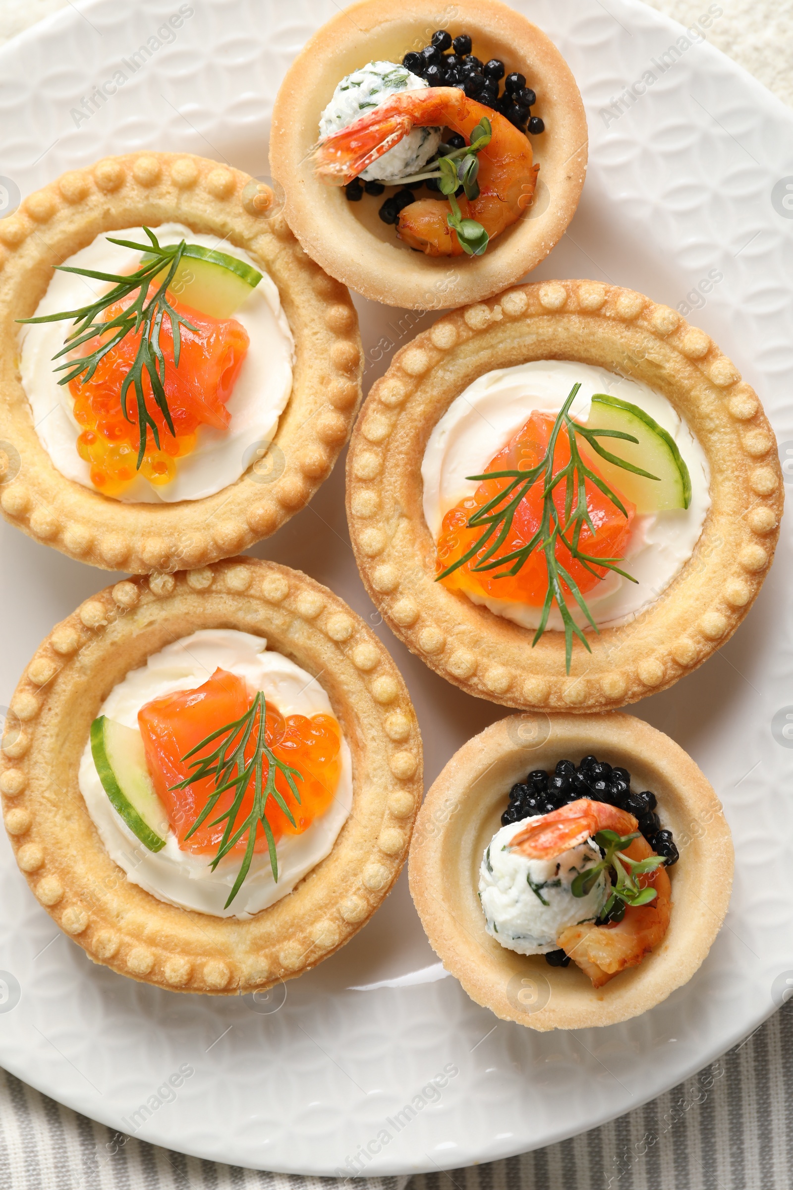 Photo of Delicious canapes with shrimps, salmon and caviar on table, top view