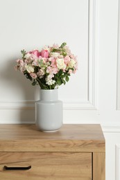 Photo of Beautiful bouquet of fresh flowers in vase on wooden table