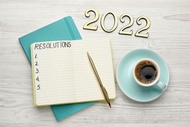 Photo of Making resolutions for 2022 new year. Flat lay composition with notebook on white wooden table