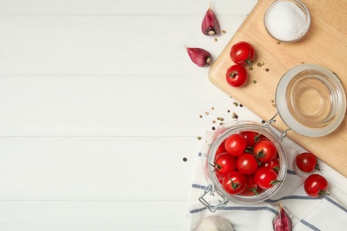 Photo of Pickling jar with fresh ripe cherry tomatoes and spices on white wooden table, flat lay. Space for text