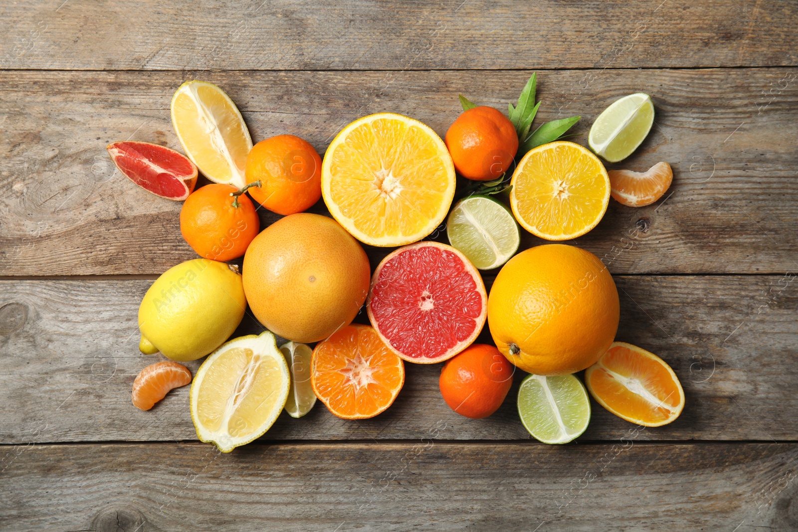 Photo of Different citrus fruits on wooden background, top view