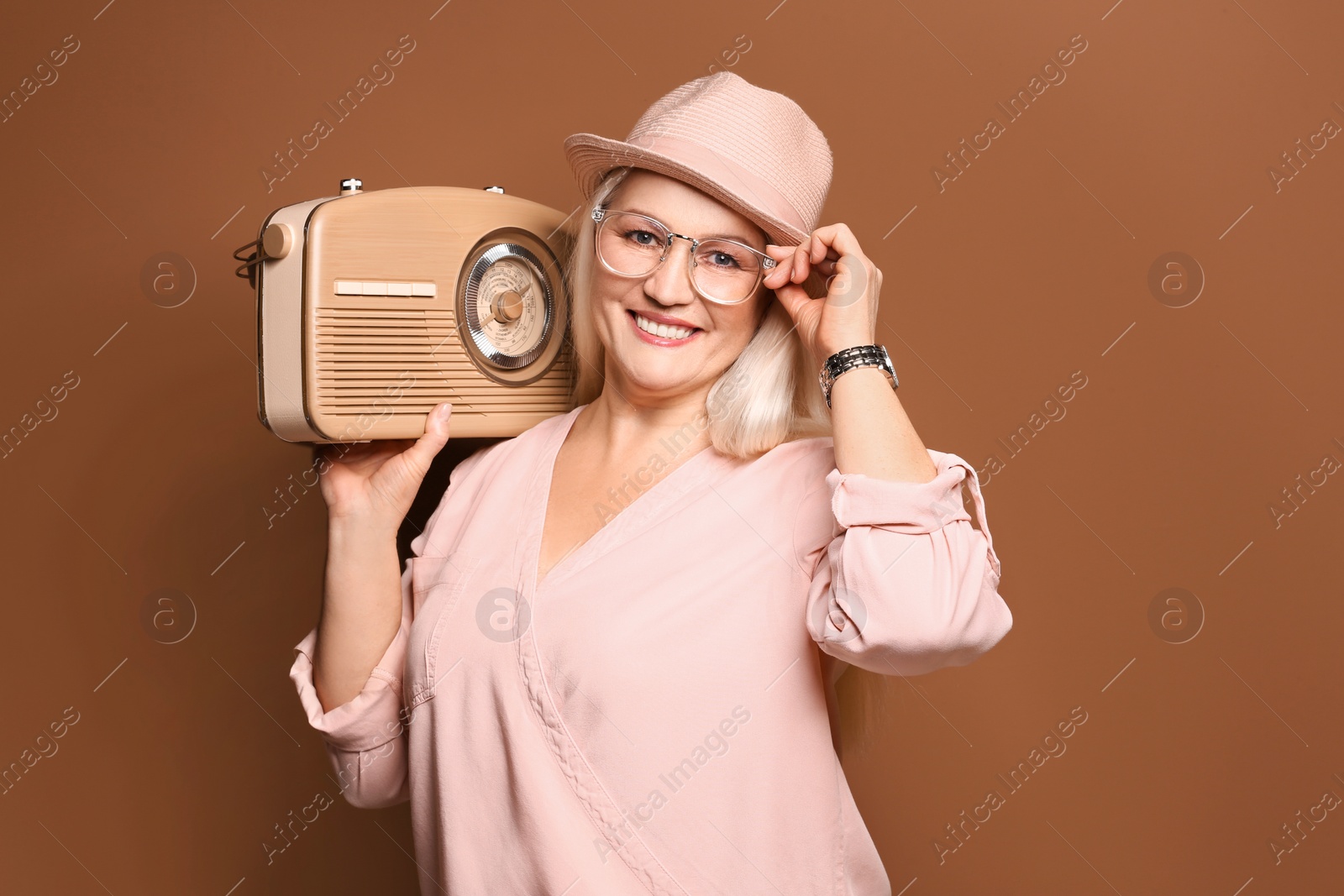 Photo of Beautiful mature woman listening to radio against color background