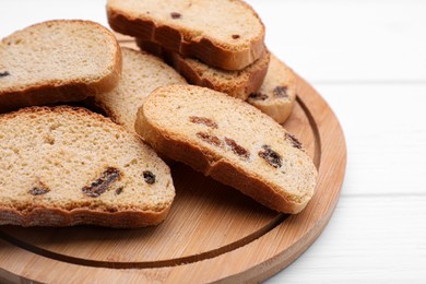 Photo of Sweet hard chuck crackers with raisins on white wooden table, closeup