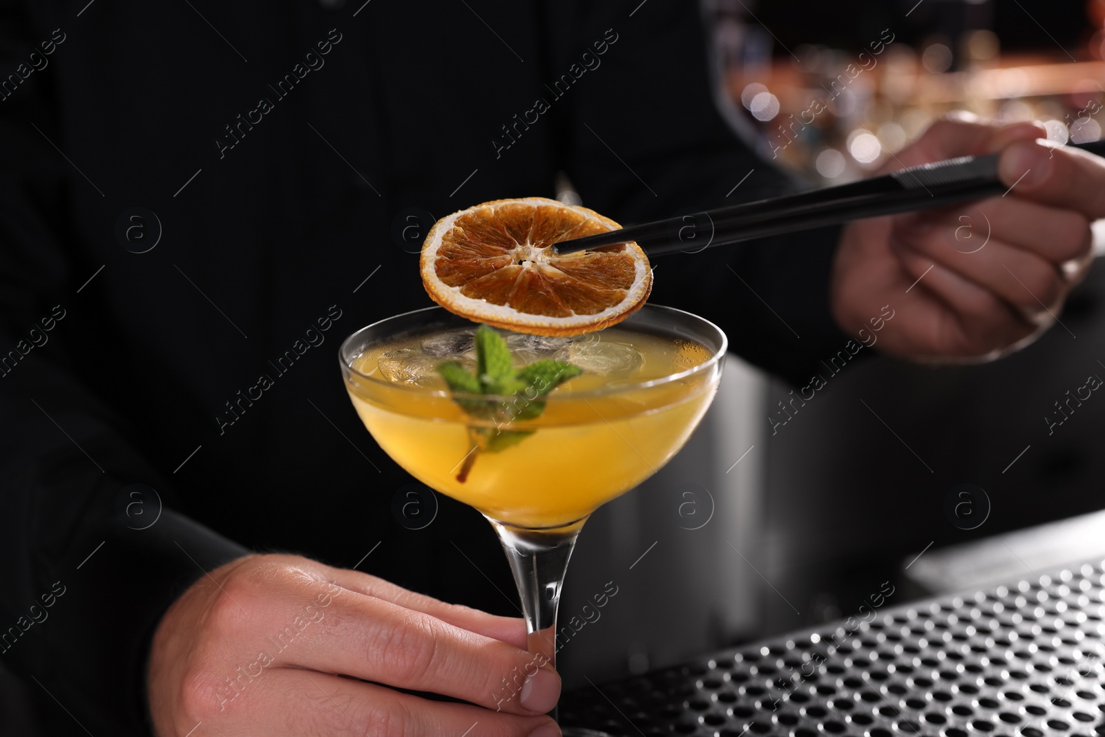 Photo of Bartender preparing fresh alcoholic cocktail in bar, closeup