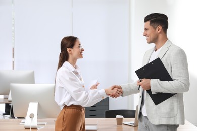 Employee shaking hands with intern in office