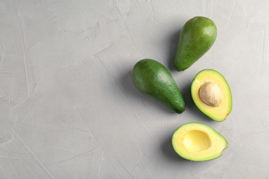 Photo of Tasty ripe green avocados on grey background, top view