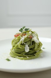 Photo of Tasty tagliatelle with spinach and cheese on plate, closeup. Exquisite presentation of pasta dish
