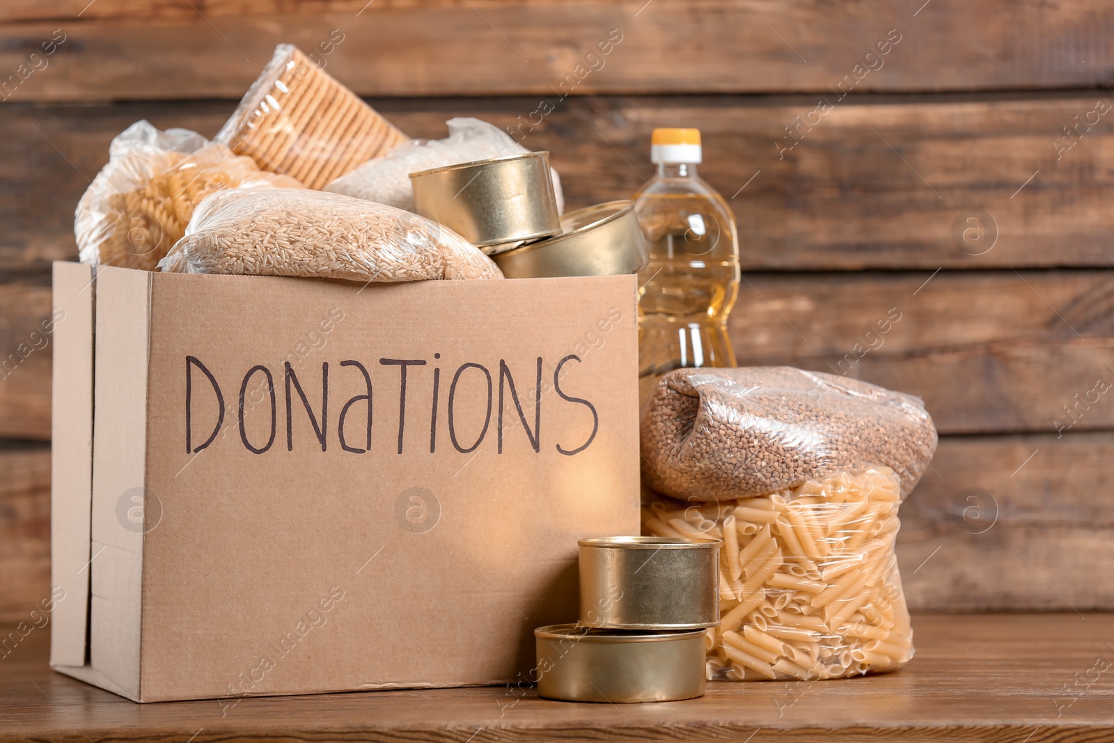 Photo of Donation box with food on wooden background