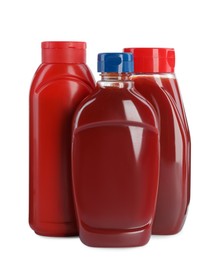 Different bottles of ketchup on white background