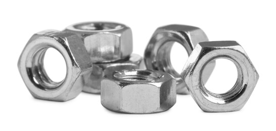 Photo of Many metal hex nuts on white background