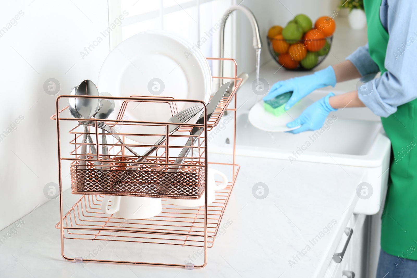 Photo of Woman washing plate in modern kitchen, closeup