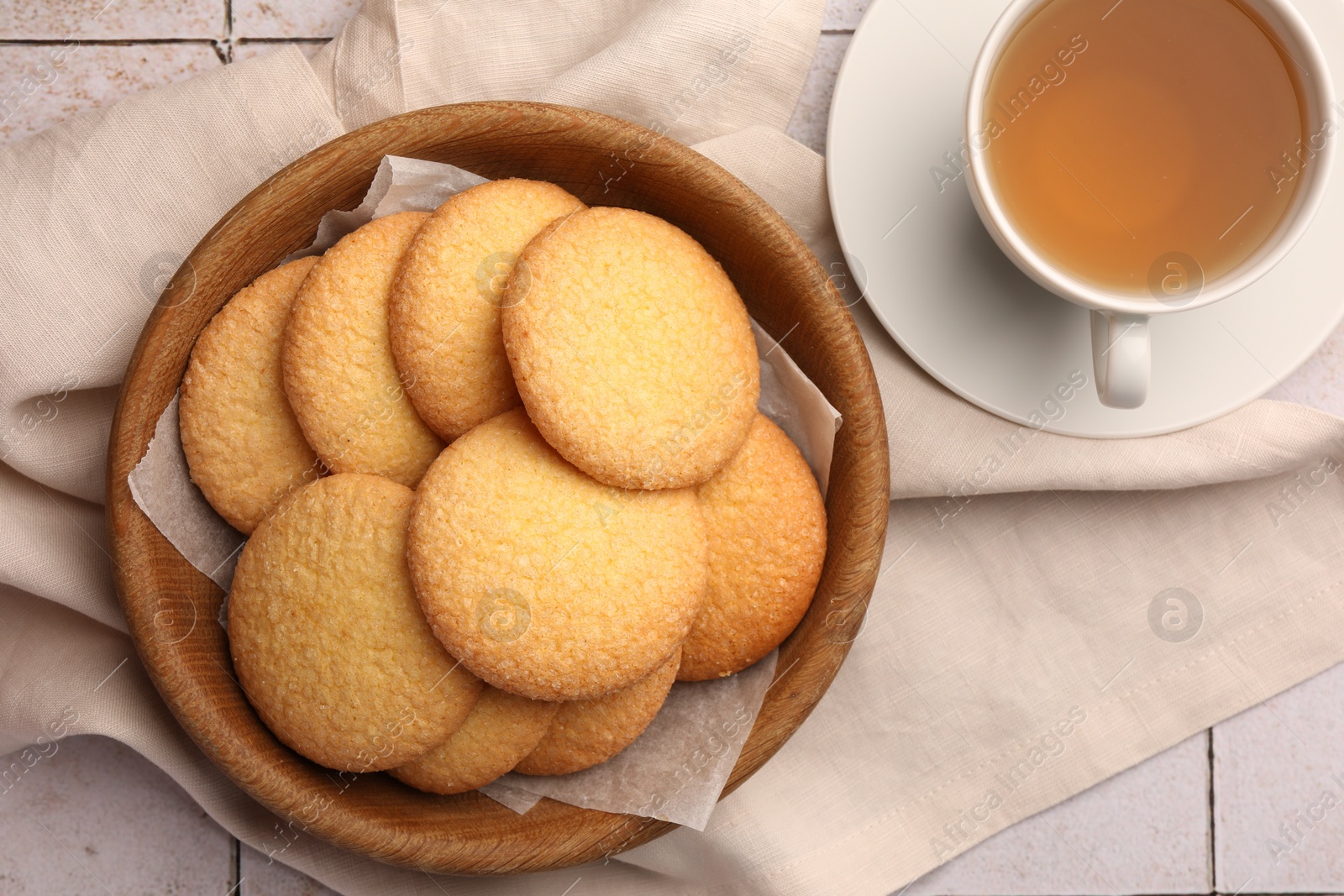 Photo of Delicious Danish butter cookies and tea on white tiled table, flat lay