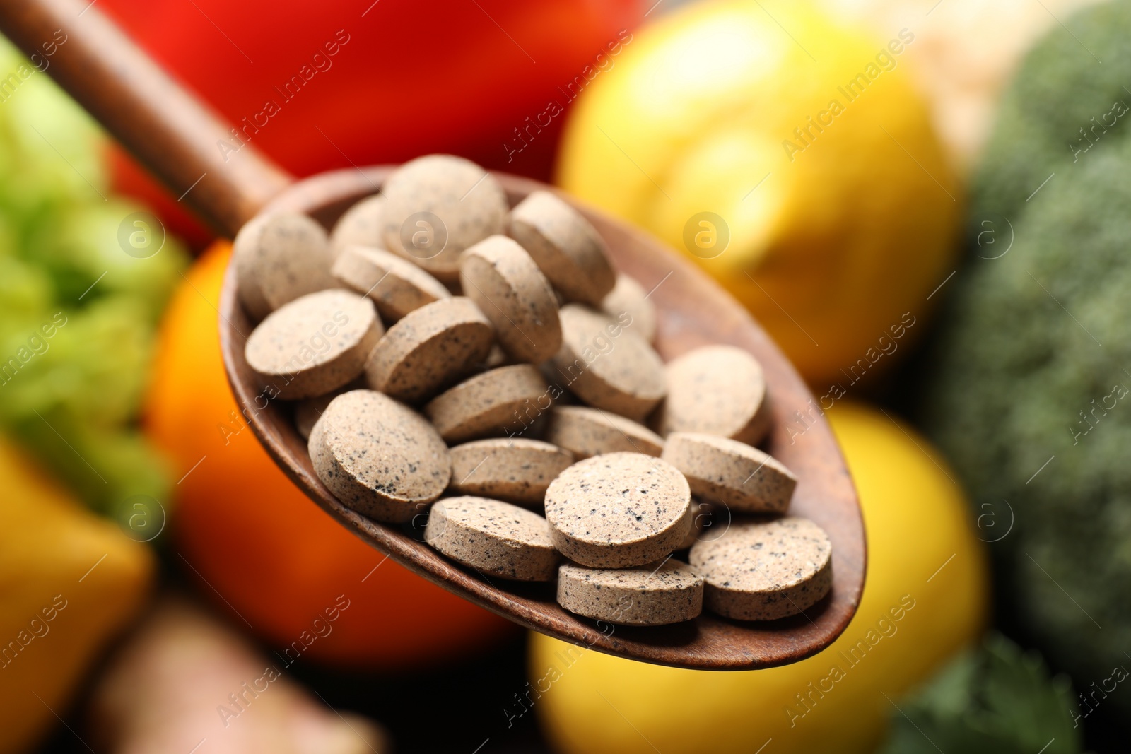 Photo of Dietary supplements. Spoon with pills over food products, closeup