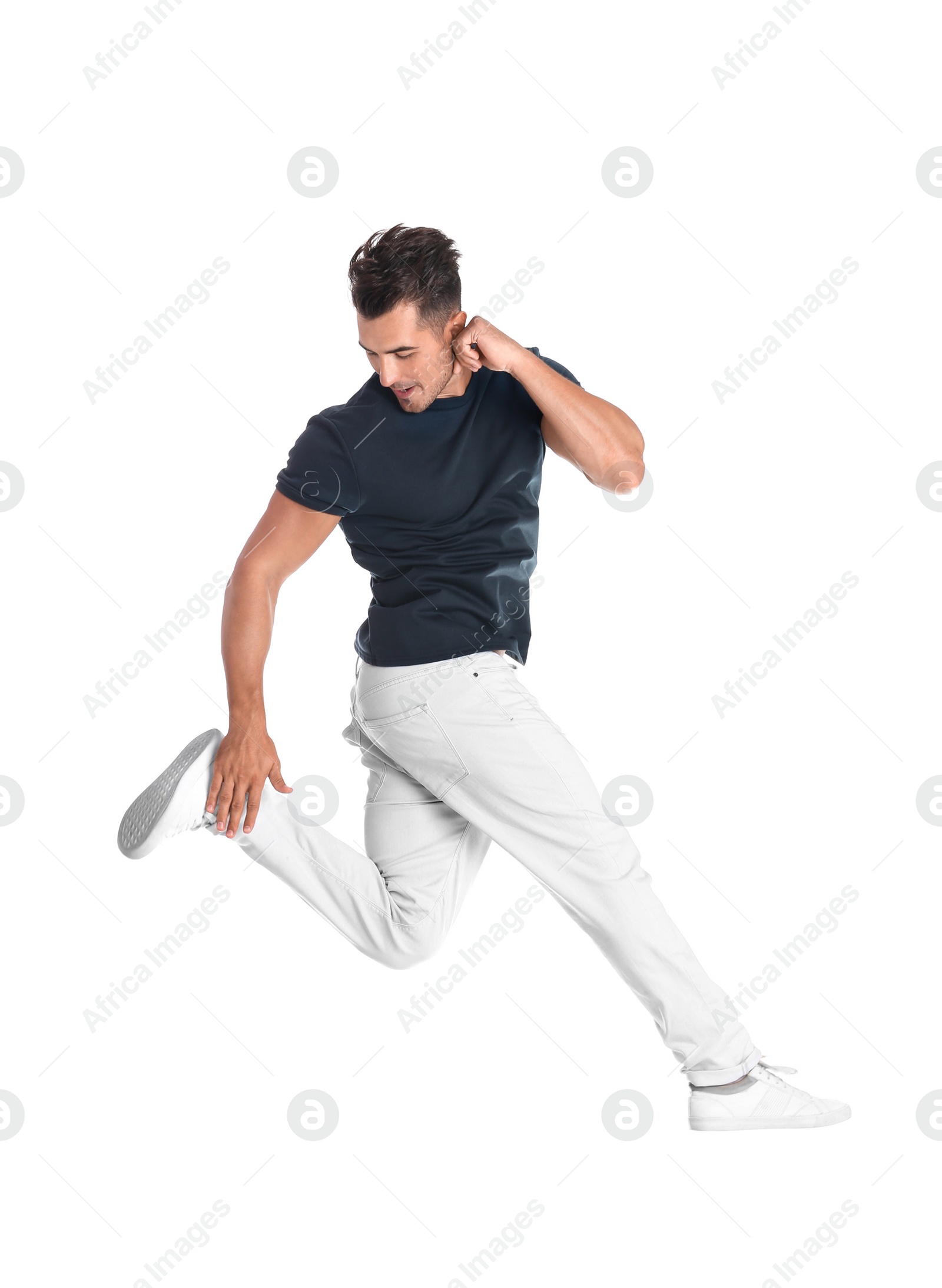 Photo of Young man in stylish jeans jumping on white background