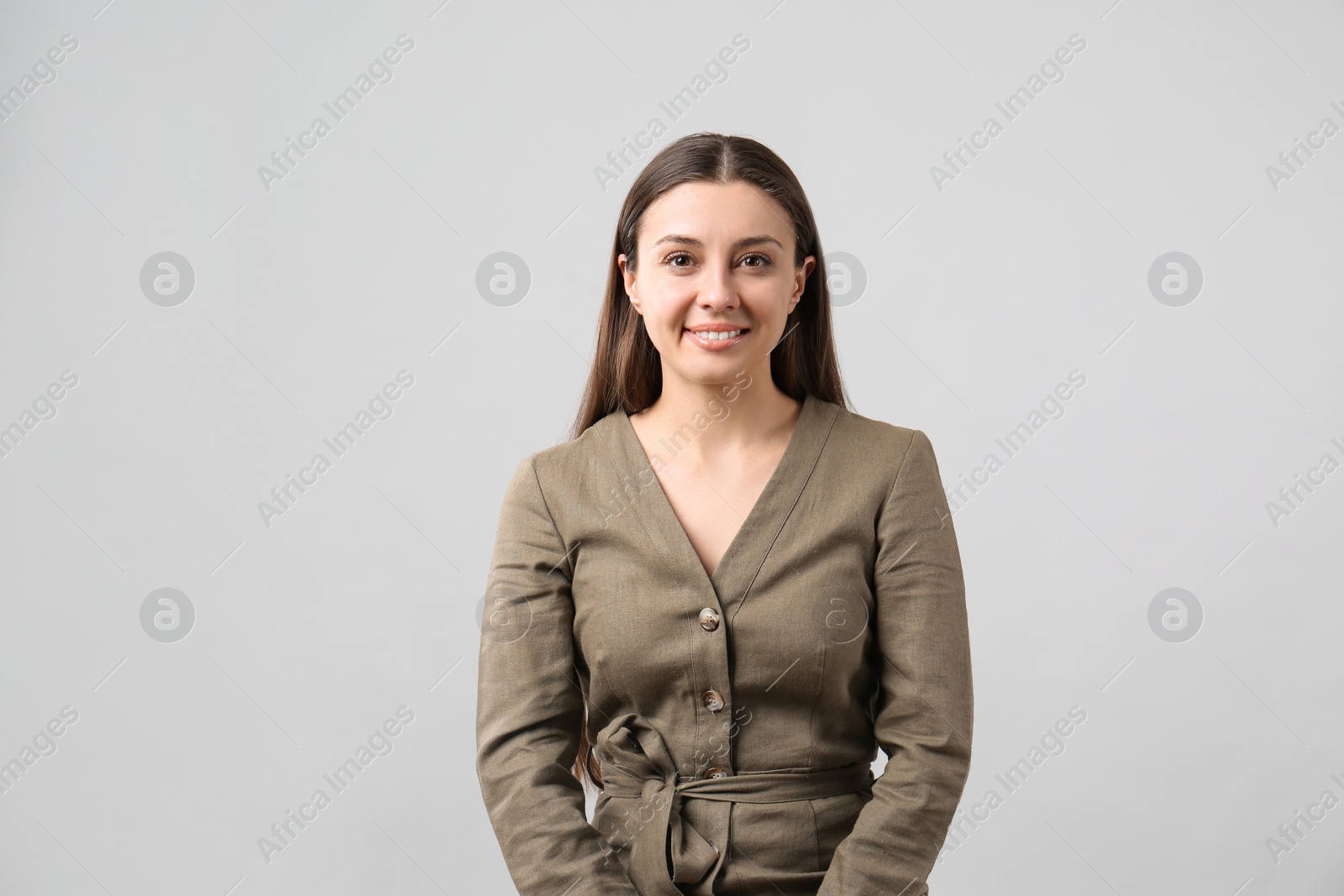 Photo of Portrait of happy young woman on light grey background. Personality concept