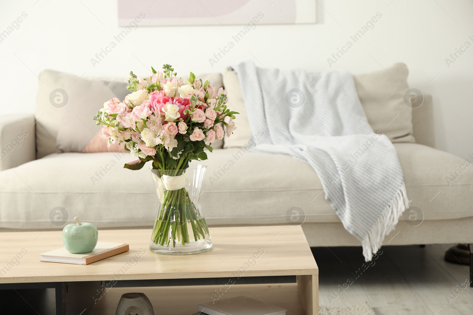 Photo of Beautiful bouquet of fresh flowers in vase on wooden table indoors