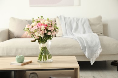 Beautiful bouquet of fresh flowers in vase on wooden table indoors