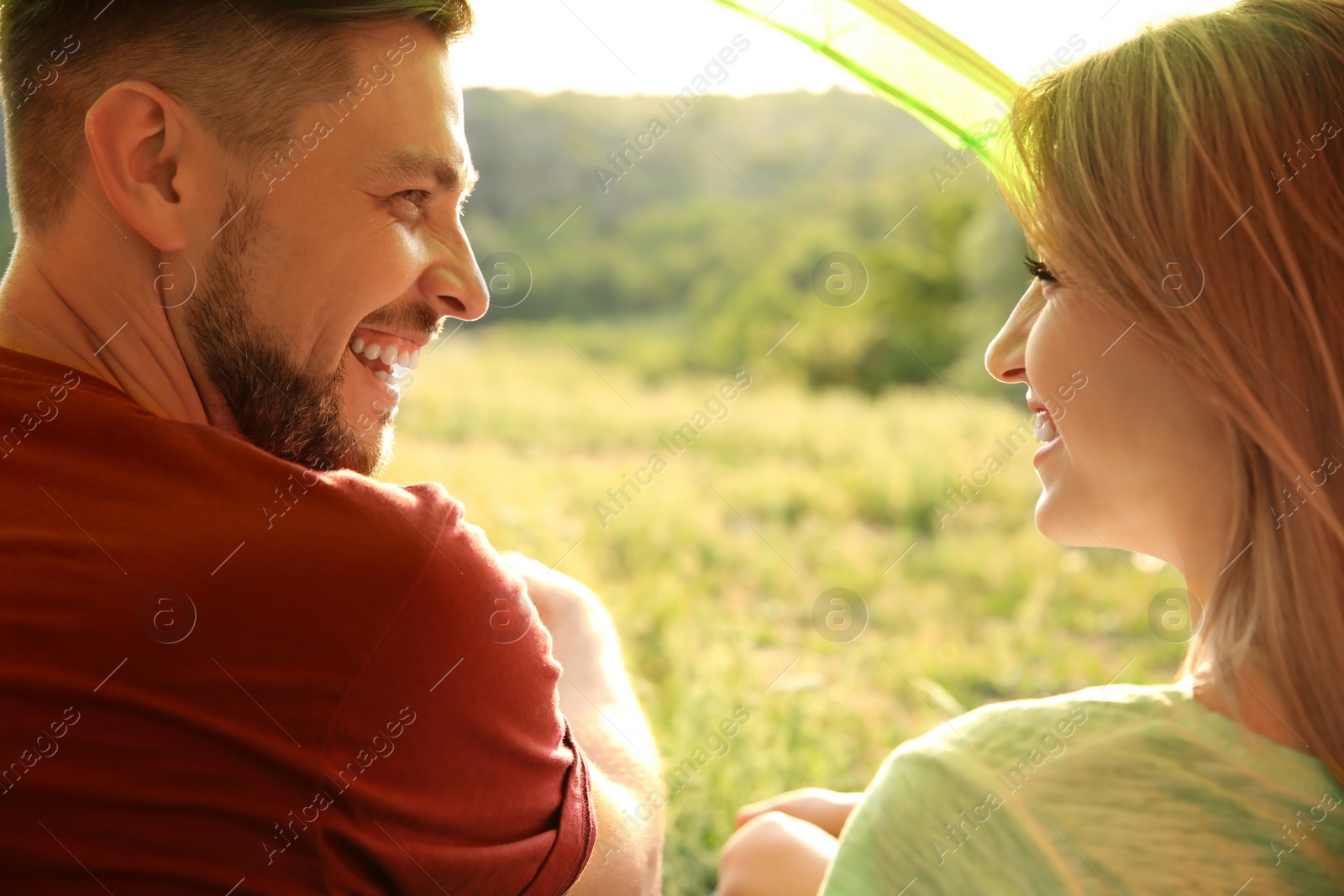 Photo of Lovely couple resting in camping tent, view from inside