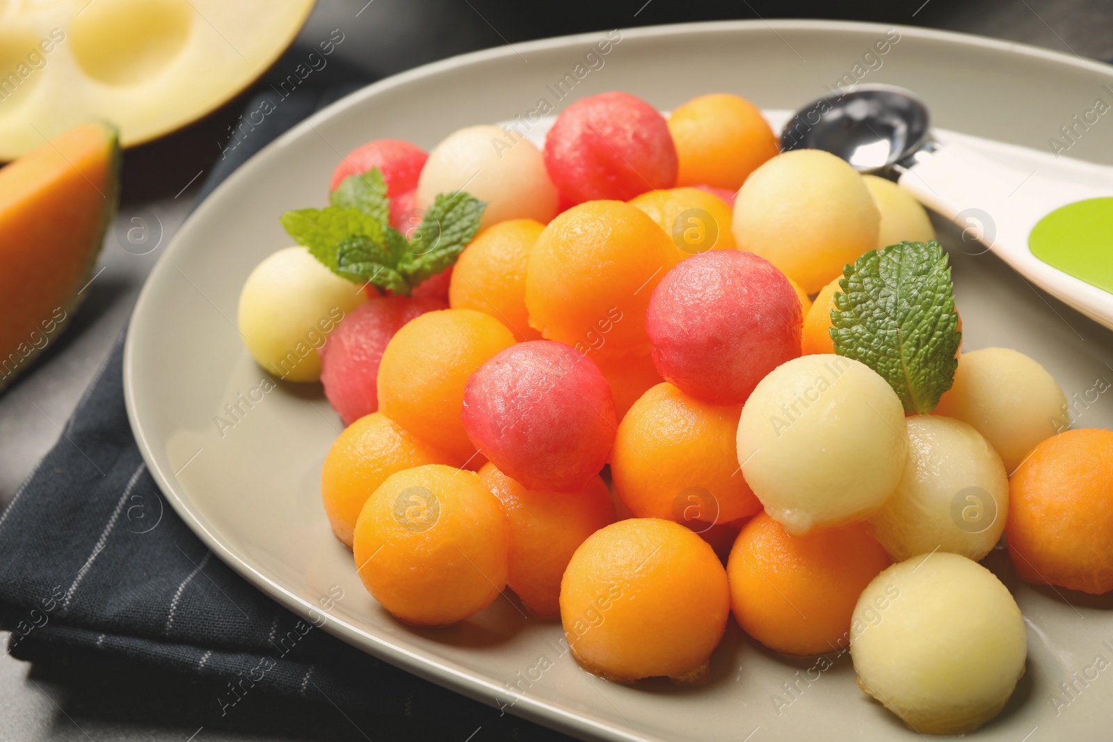 Photo of Melon and watermelon balls with mint on plate, closeup