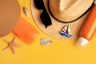 Photo of Flat lay composition with bottles of sunscreen on yellow background