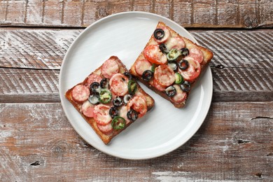 Tasty pizza toasts on wooden table, top view