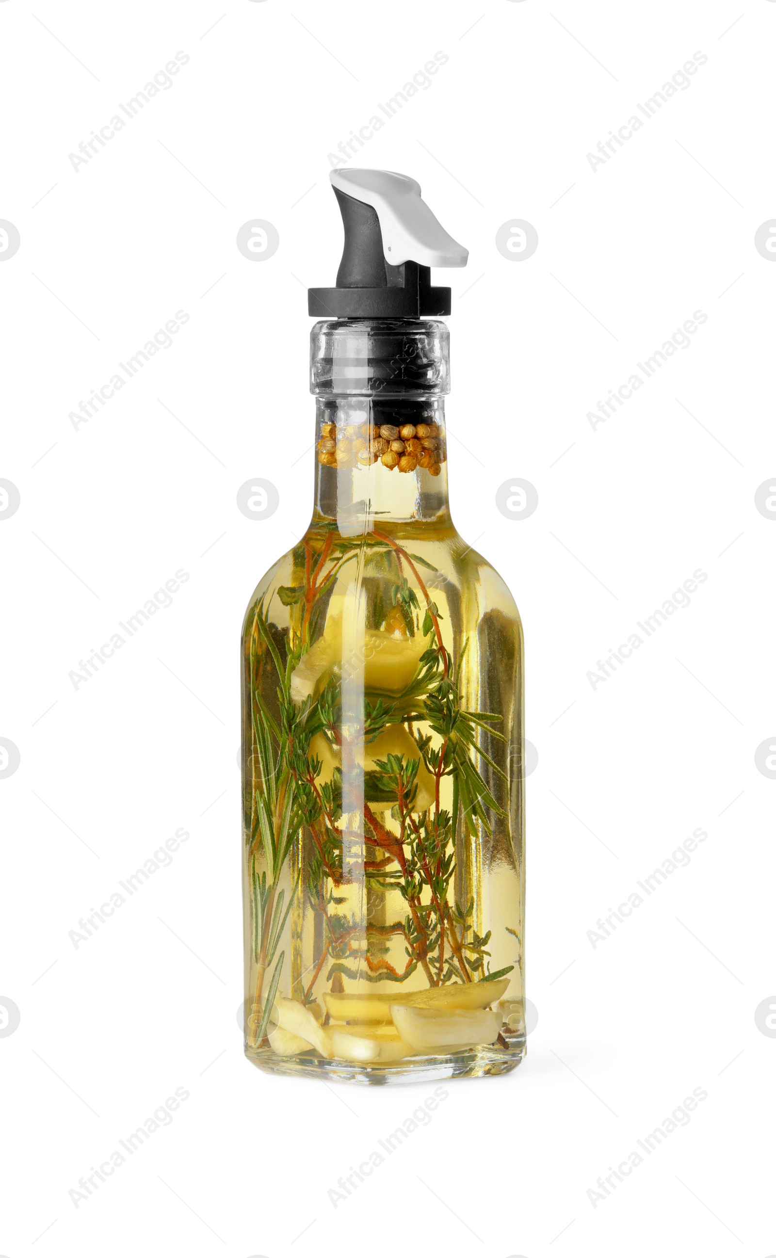 Photo of Glass bottle of cooking oil with spices and herbs isolated on white