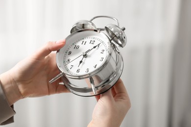 Photo of Woman with alarm clock indoors, closeup view