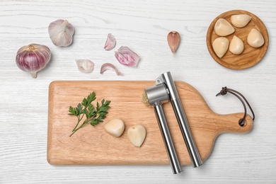 Photo of Flat lay composition with garlic press on wooden table