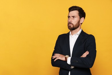 Photo of Portrait of bearded man in suit on orange background. Space for text