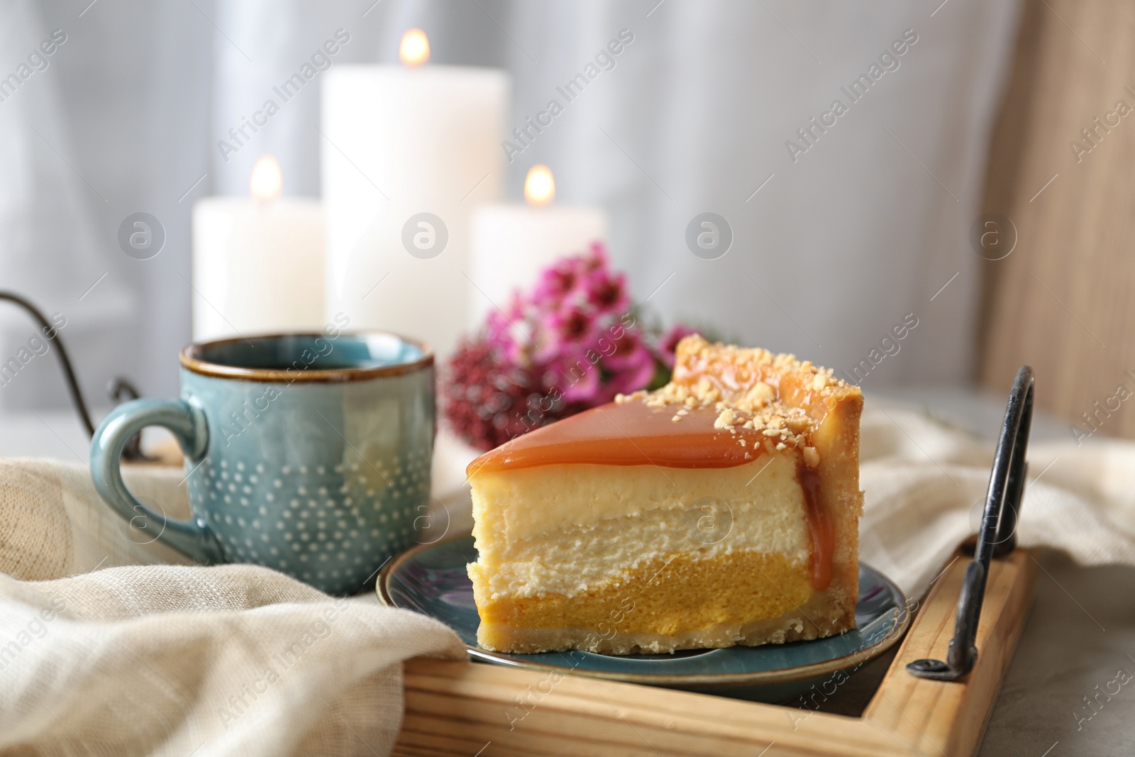 Photo of Cup of tea and delicious cheesecake on grey table, closeup