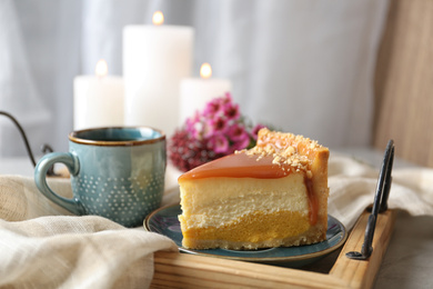 Photo of Cup of tea and delicious cheesecake on grey table, closeup