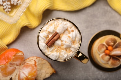 Flat lay composition with delicious marshmallow drink and yellow sweater on light grey table