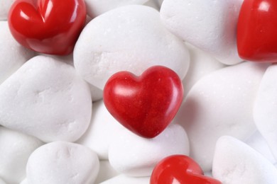 Photo of Decorative hearts on white pebble stones, above view