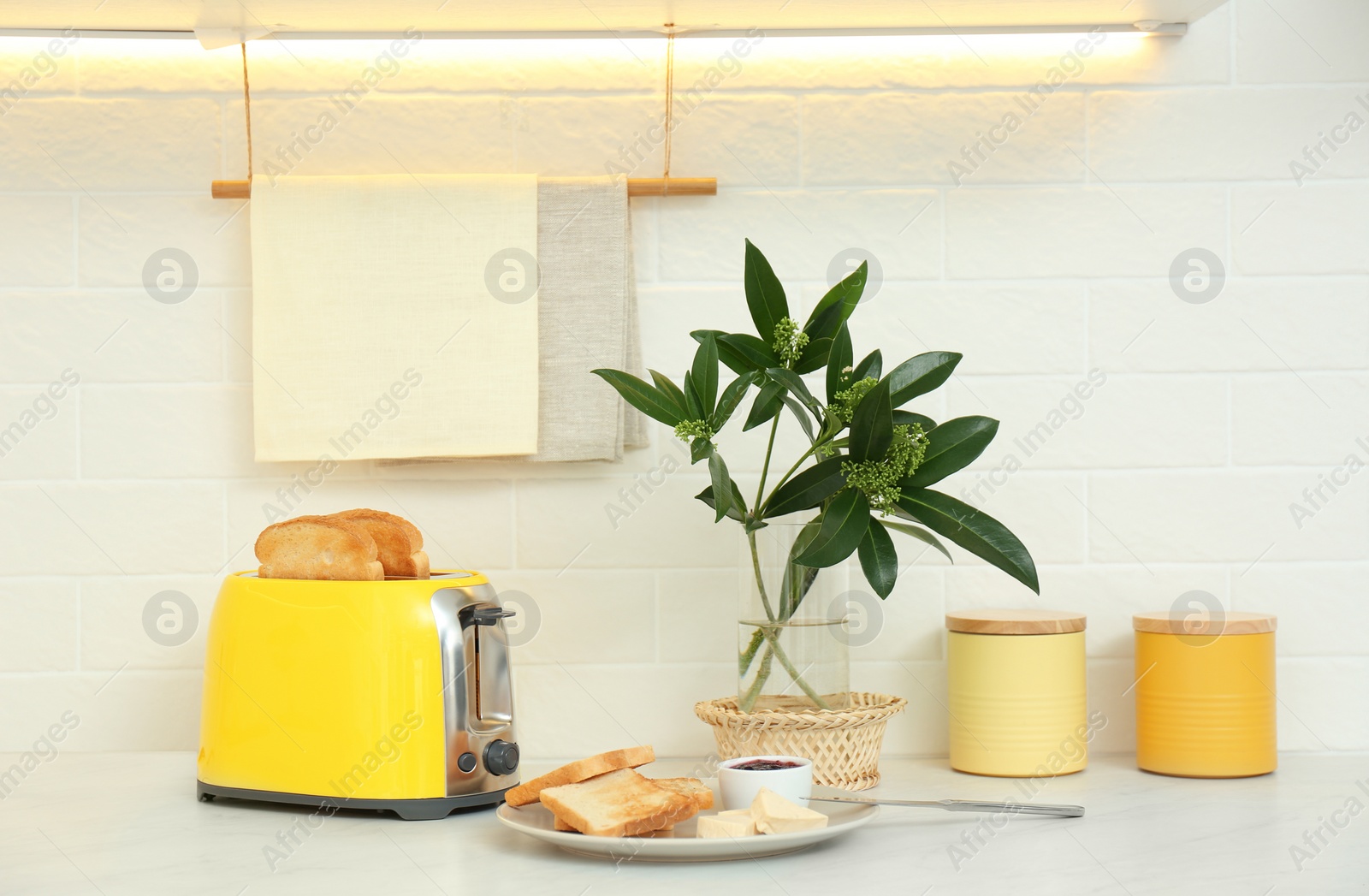 Photo of Modern toaster and tasty breakfast on counter in kitchen