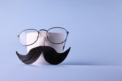 Man's face made of artificial mustache, glasses and cup on light blue background. Space for text