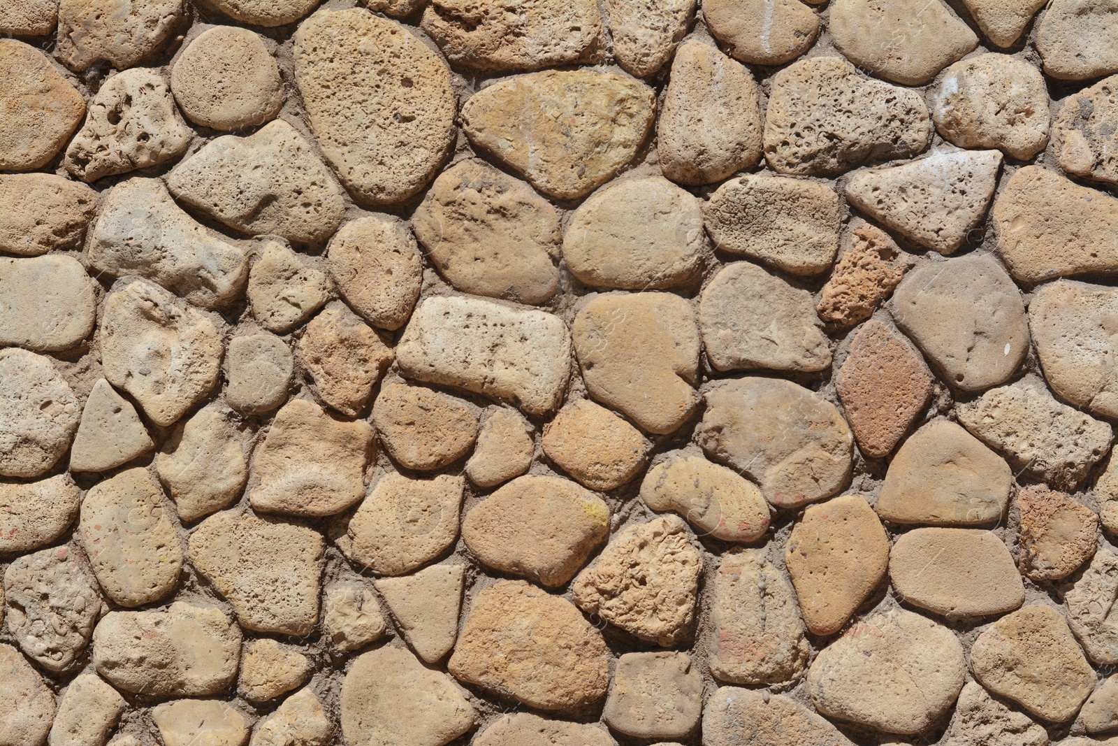 Photo of Texture of beige stone wall as background, closeup