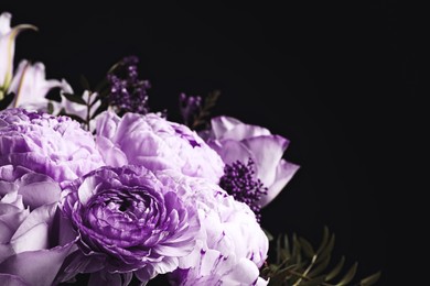 Image of Bouquet with violet flowers on black background, closeup. Funeral attributes