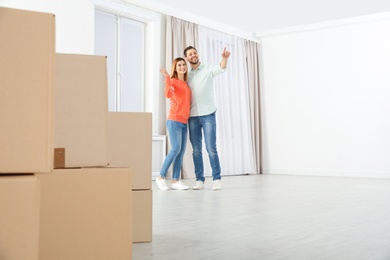 Happy couple and moving boxes in their new house