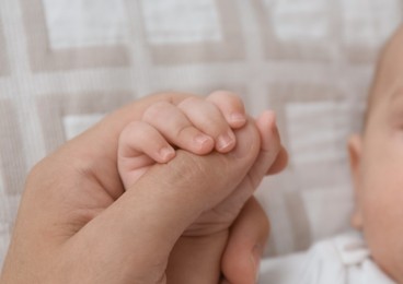 Photo of Father with his cute baby on bed, above view