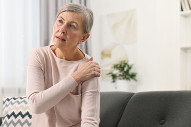 Arthritis symptoms. Woman suffering from pain in shoulder at home