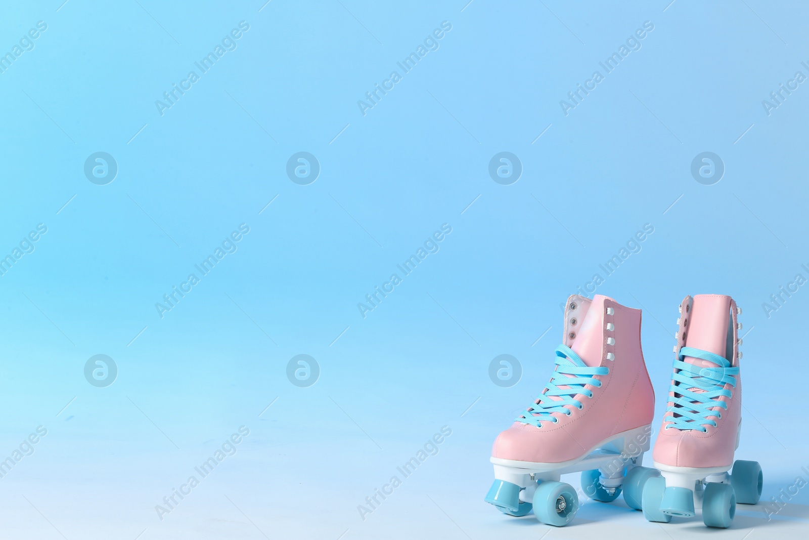Photo of Pair of vintage roller skates on color background. Space for text