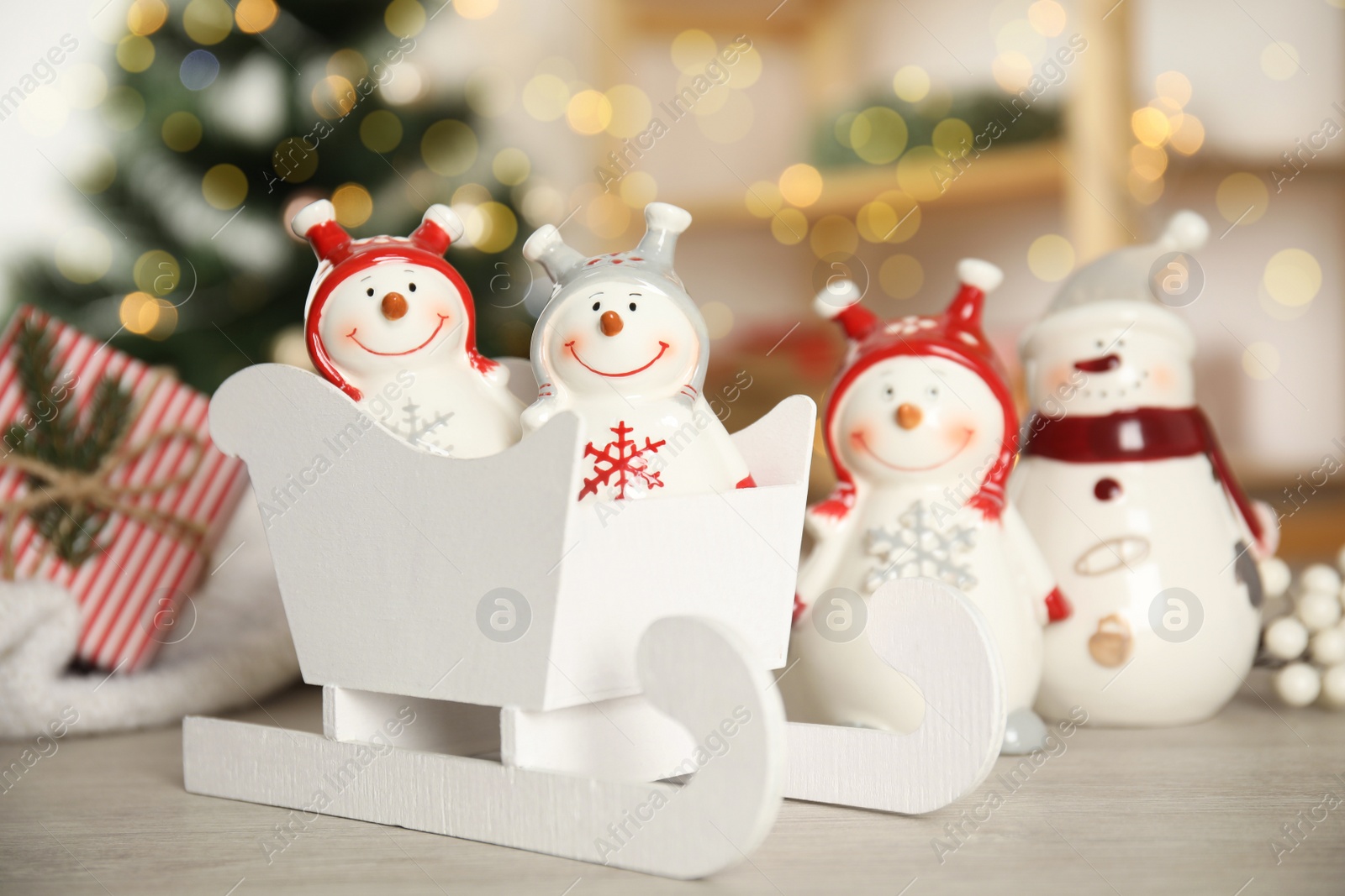 Photo of Cute decorative snowmen on table against blurred background