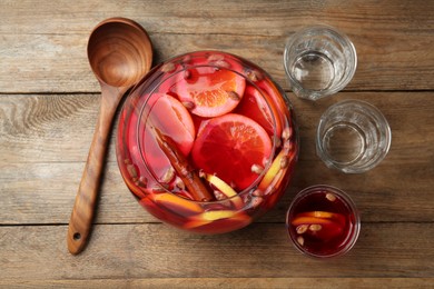 Photo of Aromatic punch drink with citrus fruits on wooden table, flat lay