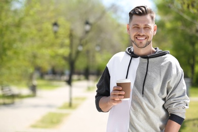 Photo of Portrait of young man with cup of coffee outdoors