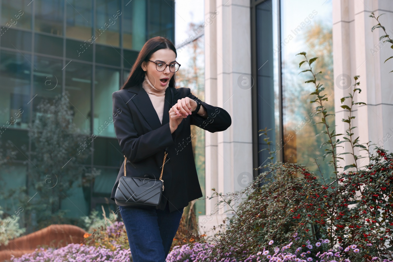 Photo of Emotional woman checking time on watch outdoors. Being late concept